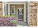 Inviting front entry with elegant wreath, potted plant, and stone accents at 19 Sangre De Cristo Dr, Durham, NC 27705