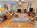 Inviting living room featuring hardwood floors, ceiling fan, and a cozy fireplace at 204 N Elliott Rd, Chapel Hill, NC 27514