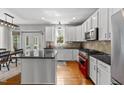 Well-lit kitchen with stainless steel appliances, a center island, and hardwood floors at 209 Brookberry Rd, Holly Springs, NC 27540
