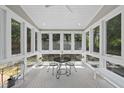 Bright sun room with large windows, tile flooring, and a charming seating area at 209 Brookberry Rd, Holly Springs, NC 27540