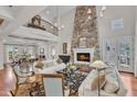 Spacious living room features a stone fireplace, hardwood floors, and open floor plan at 2117 Buckingham Rd, Raleigh, NC 27607