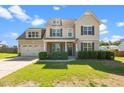 Charming two-story home featuring a manicured lawn and an inviting covered porch at 244 N Prince Henry Way, Cameron, NC 28326