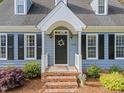 Inviting front entrance with a black door, brick steps, and lovely landscaping at 2908 Bolo Trl, Raleigh, NC 27615