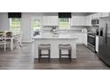 Bright kitchen with island seating, white cabinets, stainless steel appliances, and eat-in dining space at 294 N Coral Bells Way, Four Oaks, NC 27524