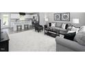 Open-concept living room featuring neutral tones, modern furniture, and a view into the kitchen at 294 N Coral Bells Way, Four Oaks, NC 27524