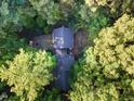 Aerial view of a charming cabin nestled among lush trees, showcasing its serene setting at 300 Rabbit Run, Pittsboro, NC 27312