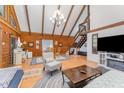 Cozy living room with wood-paneled walls, a vaulted ceiling, and comfortable seating at 300 Rabbit Run, Pittsboro, NC 27312