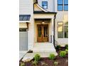 View of the front entrance featuring a beautiful wood double door, white brick stairs, and black railings at 3004 Eden Harbor Ct, Raleigh, NC 27613