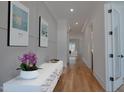Bright hallway featuring hardwood floors, paneled walls, and a console table with decorative accents at 3004 Eden Harbor Ct, Raleigh, NC 27613