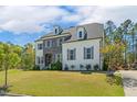 Attractive home with manicured lawn, combination stone and painted brick, and mature trees at 304 Channel Cove Dr, Holly Springs, NC 27540