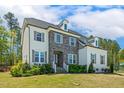 Attractive home with manicured lawn, combination stone and painted brick, and mature trees at 304 Channel Cove Dr, Holly Springs, NC 27540