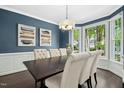 Lovely dining room featuring wainscoting, dark wood table, and large windows at 308 Hassellwood Dr, Cary, NC 27518