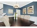 View of dining room with large wooden table, chandelier, and blue accent wall at 308 Hassellwood Dr, Cary, NC 27518