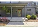 Inviting front porch with dark gray painted brick, a stylish front door, and lush landscaping at 310 Georgetown Rd, Raleigh, NC 27608