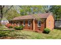 Side angle of all-brick home with manicured lawn, mature trees, and flowering bushes at 3126 Truitt Dr, Burlington, NC 27215