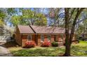 Quaint one-story brick home featuring blooming bushes, mature landscaping, and a cozy feel at 3126 Truitt Dr, Burlington, NC 27215