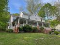 Exterior home view featuring the long porch and complemented by a lush green lawn at 330 W King St, Hillsborough, NC 27278