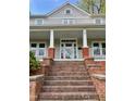 Inviting covered front porch with brick pillars and access to the home's entrance at 330 W King St, Hillsborough, NC 27278