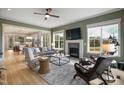 Bright living room featuring hardwood floors, large windows, a cozy fireplace, and stylish furnishings in an open layout at 337 Sunset Hill Ln, Wendell, NC 27591