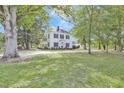 Spacious green lawn surrounds this two-story home in an idyllic landscape of lush trees at 3521 Banks Rd, Raleigh, NC 27603