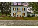 Charming two-story home with black shutters, inviting lighting, and a brick pathway to the front entrance at 3521 Banks Rd, Raleigh, NC 27603