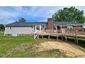 Back of the home featuring a deck, brick chimney, vinyl siding, and a well-maintained lawn at 3785 Little Creek Church Rd, Clayton, NC 27520