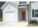 Inviting home exterior featuring a covered entry with a wreath on the door and an attached one-car garage at 39 Principal Way, Clayton, NC 27520