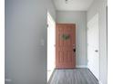 Open foyer showcasing a stylish front door with wreath, gray walls, wood-look floors, and white trim at 39 Principal Way, Clayton, NC 27520