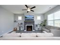 Comfortable living room features a fireplace, TV, ceiling fan, and neutral decor at 39 Principal Way, Clayton, NC 27520