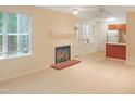 Comfortable living room featuring fireplace, neutral walls, carpet, and a bar separating the kitchen at 403 Gooseneck Dr # A-1, Cary, NC 27513