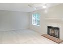 Bright living room featuring a cozy fireplace, neutral walls, and a ceiling fan at 403 Gooseneck Dr # A-1, Cary, NC 27513