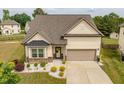 Well-maintained home featuring tidy landscaping, a two-car garage, and a welcoming entrance at 404 Lily Pad Ct, Zebulon, NC 27597