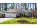 Charming single-story home featuring a two-car garage, well-manicured lawn, and mature trees at 4331 Millcreek Cir, Pittsboro, NC 27312