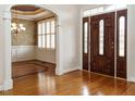 Elegant foyer with hardwood floors, an archway, and a view into the dining area with detailed wainscoting at 4501 Forest Dr, Holly Springs, NC 27540