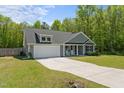 Lovely home with a two-car garage, neutral siding, and a green lawn, set against a backdrop of lush trees at 479 Kotata Ave, Bunnlevel, NC 28323
