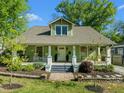 Inviting two-story home with a classic design and a lovely front porch, surrounded by lush greenery at 501 Mallard Ave, Durham, NC 27701