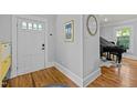 Bright foyer with hardwood floors, showcasing a view into a living space with a grand piano at 501 Mallard Ave, Durham, NC 27701