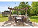 Outdoor dining area with stone BBQ and Pergola on stone patio at 5525 Sandy Trail Dr, Knightdale, NC 27545