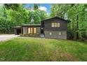Charming home featuring an attached garage, gray brick, black trim, and lush green lawn at 6421 Arrington Rd, Raleigh, NC 27607