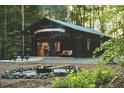 Beautiful home exterior with a fire pit area, surrounded by lush greenery, ideal for outdoor entertaining at 665 Lonach Ln, Roxboro, NC 27574