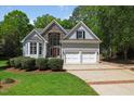 Charming two-story home featuring a stone facade, two-car garage, and manicured lawn at 6819 Rainwater Rd, Raleigh, NC 27615