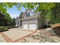 Side angle view of home featuring a two-car garage and manicured lawn at 6819 Rainwater Rd, Raleigh, NC 27615