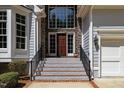 A close-up of home's front entrance featuring a stone facade and wood door at 6819 Rainwater Rd, Raleigh, NC 27615