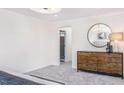 Bright bedroom with a modern dresser, round mirror, and ensuite bathroom access at 718 Colby Pl, Durham, NC 27713