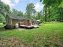 Spacious backyard featuring a wooden deck with a hot tub and patio furniture, perfect for outdoor entertaining at 725 Van Thomas Dr, Raleigh, NC 27615