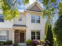 Inviting two-story townhome featuring light siding, brick detail, and lush landscaping at 7851 Allscott Way, Raleigh, NC 27612