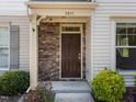 Charming brick entrance to a townhome with lush green and auburn landscaping at 7851 Allscott Way, Raleigh, NC 27612