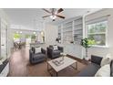 Cozy living room with built-in shelving, ceiling fan, and view to kitchen and dining area at 7851 Allscott Way, Raleigh, NC 27612