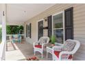 Inviting front porch with stylish seating, including wicker chairs and decorative pillows and plants at 919 Orient St, Durham, NC 27701