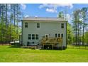 Backyard view of home featuring a wood deck, lush lawn, and a surrounding wood fence at 101 Yuma Dr, Louisburg, NC 27549